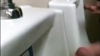 two slim dicks getting wanked at the urinals