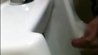 two slim dicks getting wanked at the urinals