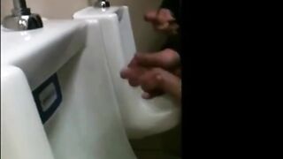 two slim dicks getting wanked at the urinals