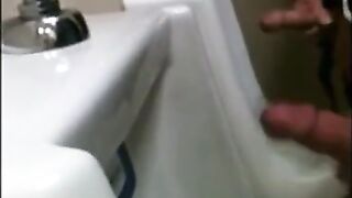 two slim dicks getting wanked at the urinals