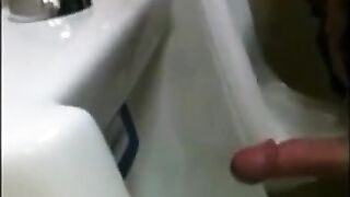 two slim dicks getting wanked at the urinals